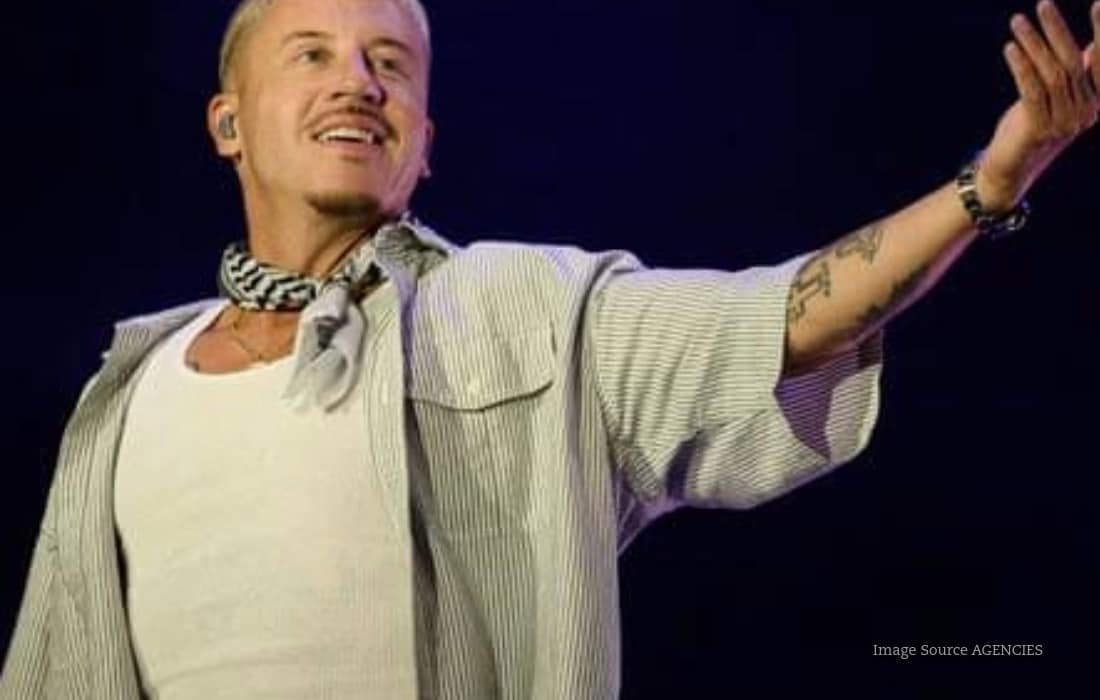 Macklemore performing on stage after pledging $1 million in Loop Tour earnings to organisations supporting Palestinians.