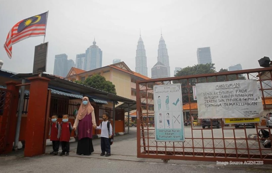 Kuala Lumpur skyline covered in dense haze as Malaysian authorities close schools due to unhealthy air pollution levels.