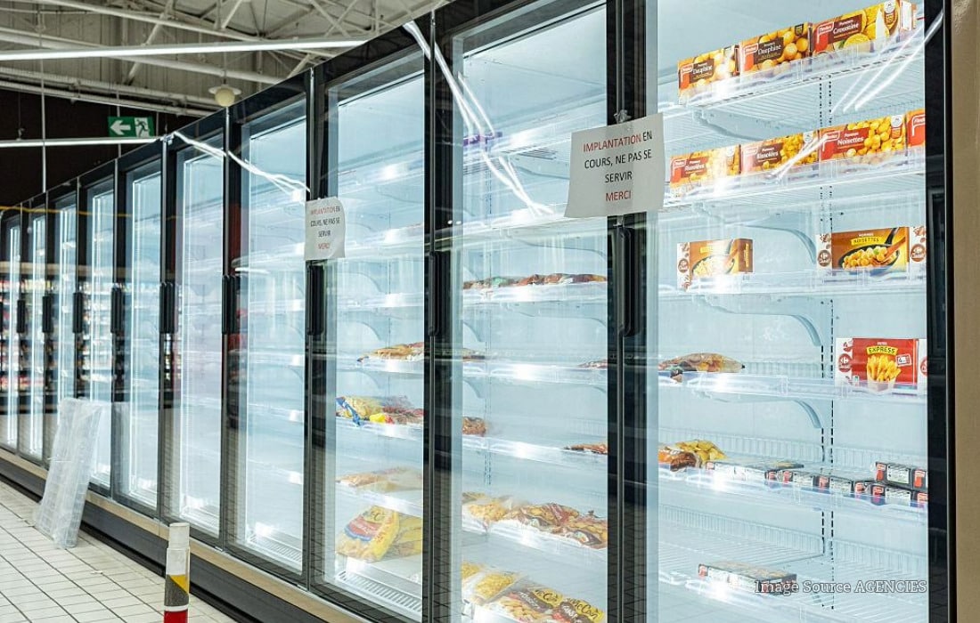 Closed supermarket refrigeration aisle in France following cyberattack that damaged food supplies.